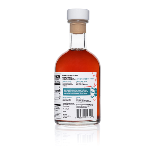 Back view of American Vinegar Works 19.53 Miles From The Tree Apple Cider Vinegar bottle showing label and amber liquid inside.