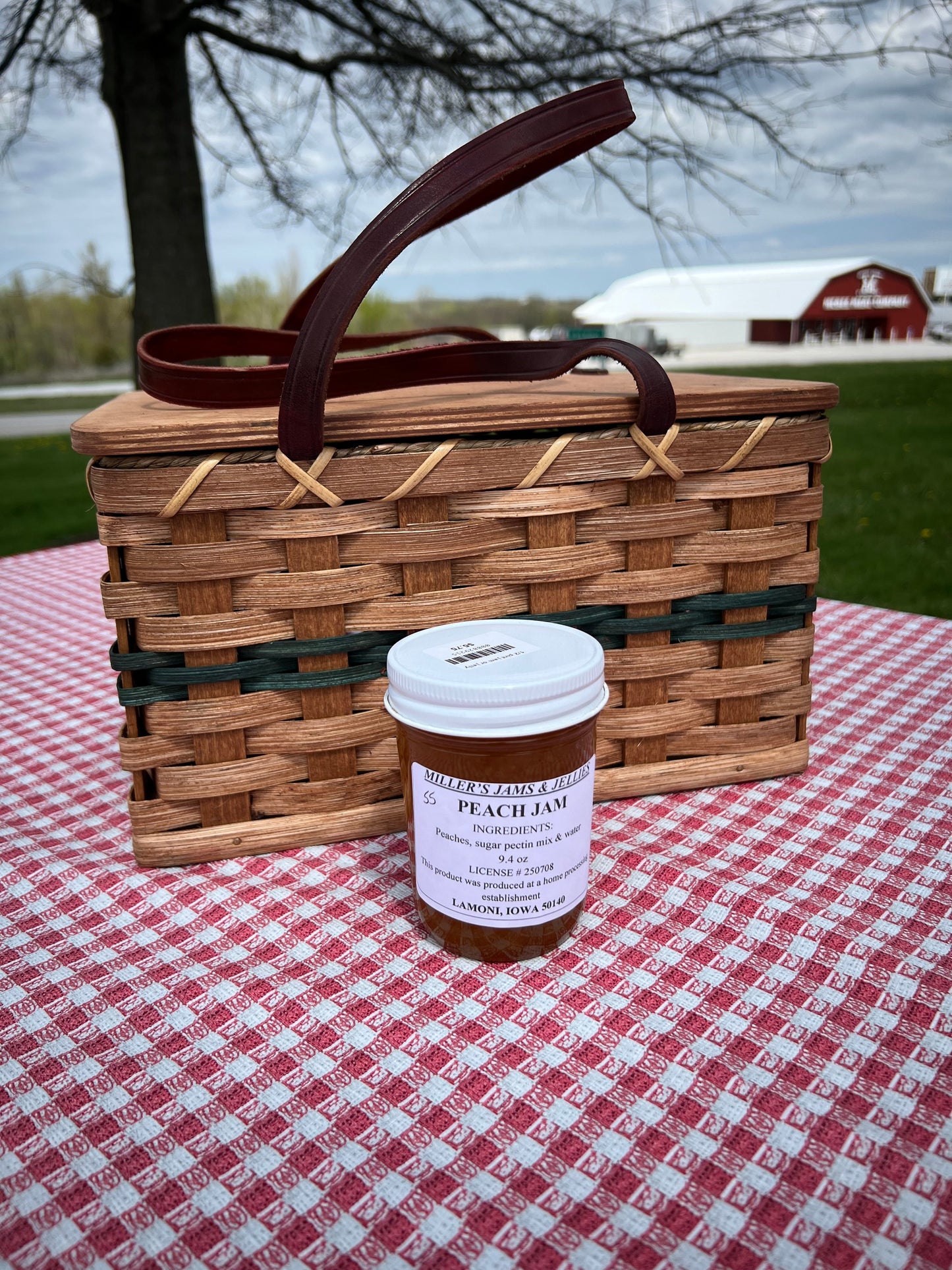 Amish Country Store Miller's Peach Jam jar, showing fresh peach jam with a label, on a rustic wooden surface.