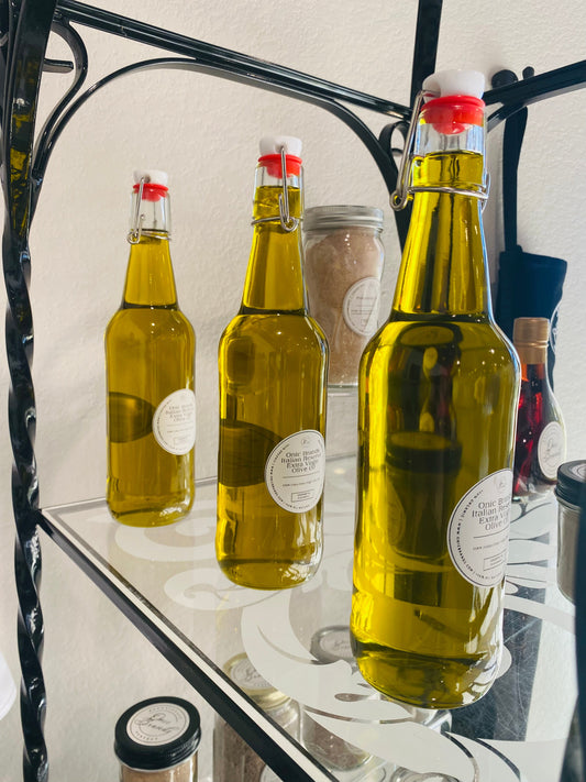 Onic Brands Italian Reserve extra virgin olive oil bottle with a dark label and gold cap, placed on a wooden surface.
