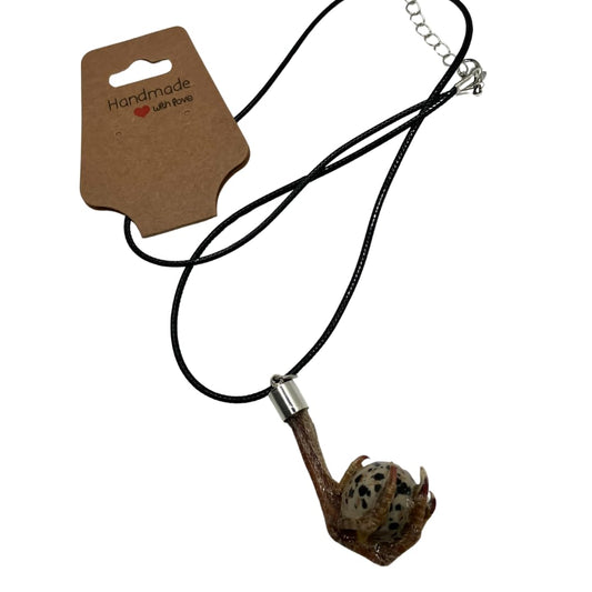 Quail foot necklace featuring a stone resembling a quail egg, crafted by Quailz.com with a rustic metal chain.