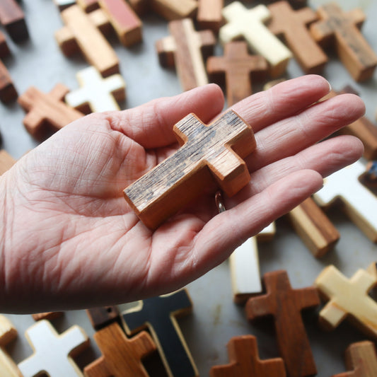 Handmade wooden pocket cross by Dennehey Design Co. featuring a detailed carved wooden cross with smooth finish and compact size.