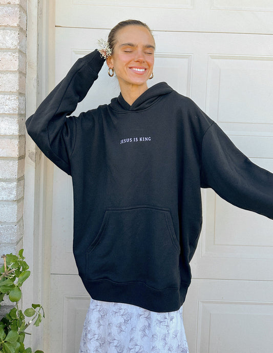 Black unisex hoodie with "Jesus Is King" graphic from Elevated Faith, featuring a comfortable fit and bold religious design.