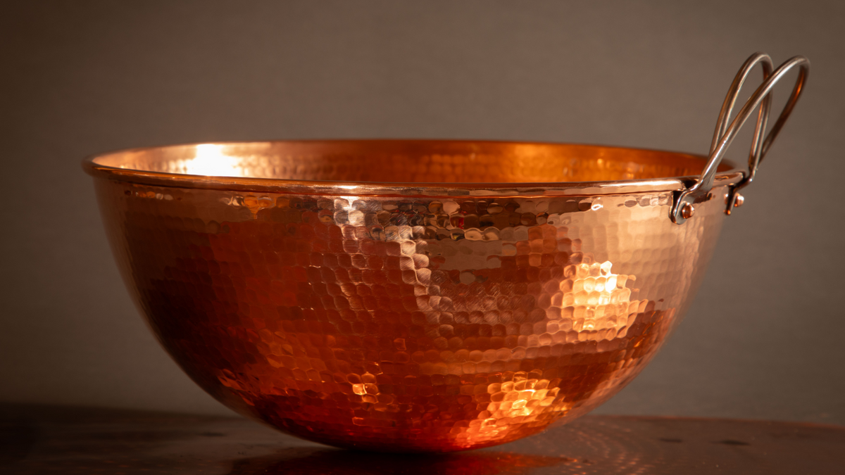 Set of three Sertodo copper mixing bowls stacked, showcasing shiny, handcrafted copper surface and rounded shape.