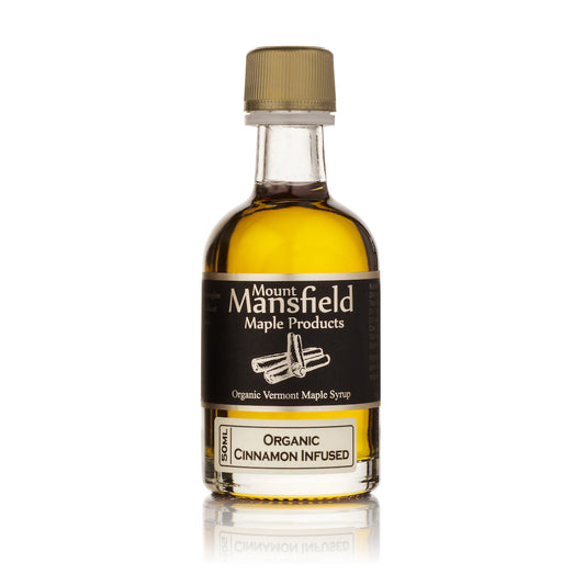 Cinnamon stick-infused Vermont maple syrup in a 50ml bottle, with cinnamon pieces visible inside, from Mount Mansfield Maple Products.