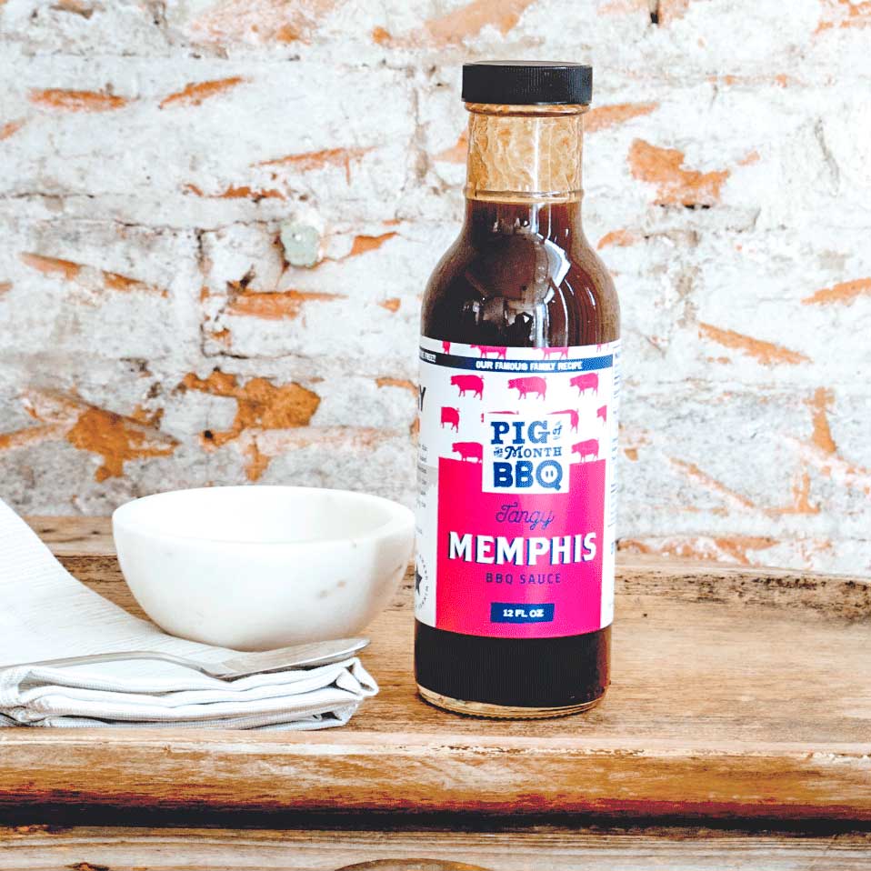Smoked meats kit by Pig of the Month BBQ with pulled pork, brisket, and chicken, topped with Memphis-style BBQ sauce.