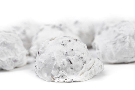 Individual pecan divinity treat from Millican Pecan, featuring creamy white texture with whole pecans on top.