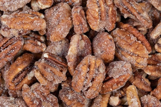 Millican Pecan cinnamon candied pecans in a 12oz bag, showing crunchy coated pecans with a cinnamon sugar glaze.