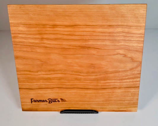 Cherrywood cutting board by Farmer Bill's Provisions, made and sourced in the USA, featuring a smooth surface and natural wood grain.