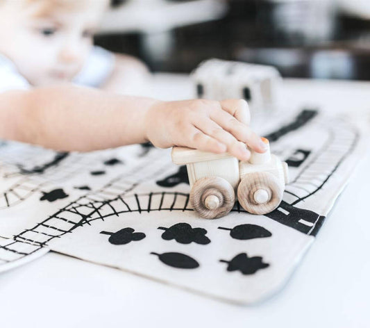 Colorful train play mat for toddlers by So Handmade Shop featuring portable travel tracks on soft fabric surface.