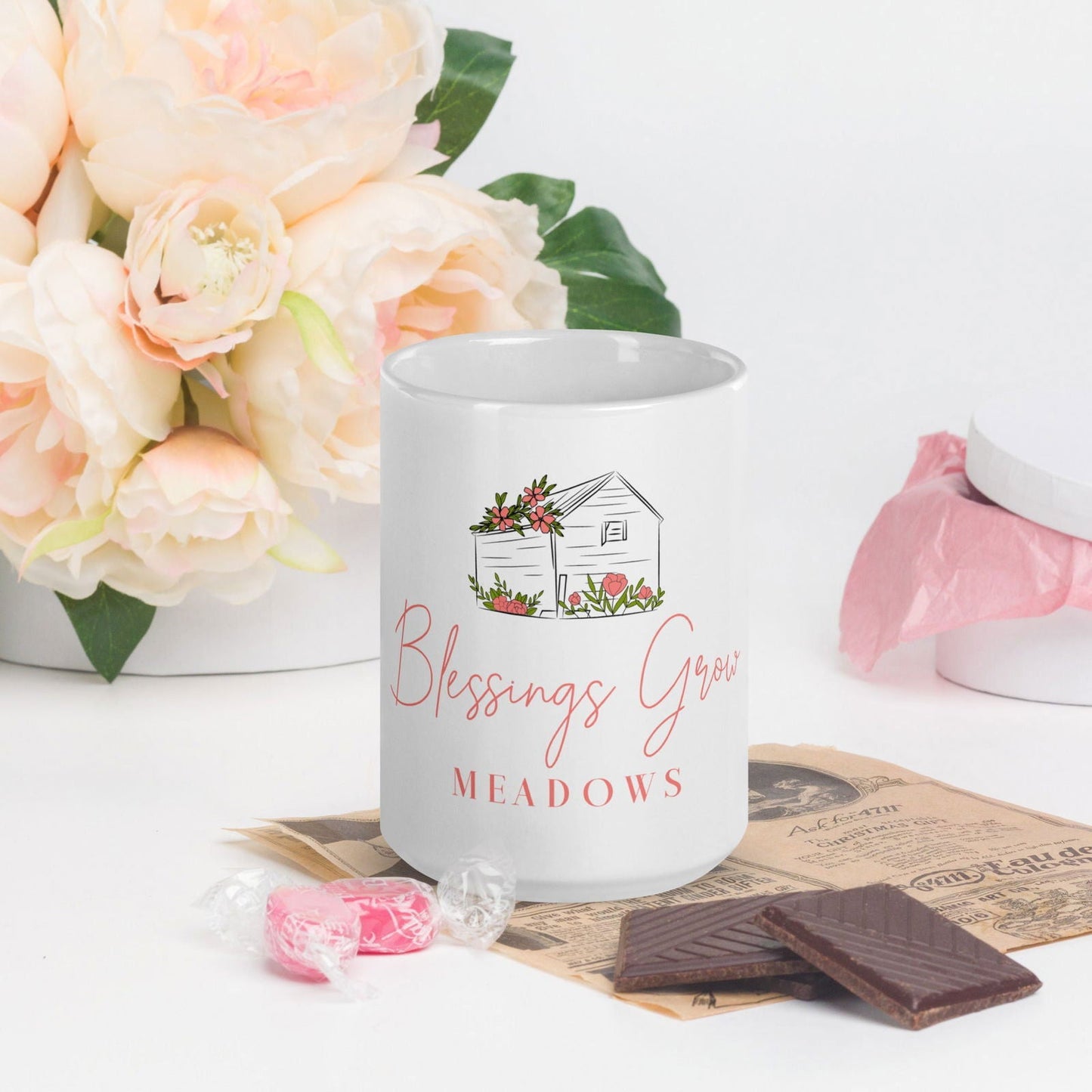 White glossy Blessings Grow Meadows mug with a simple design, perfect for enjoying hot beverages.
