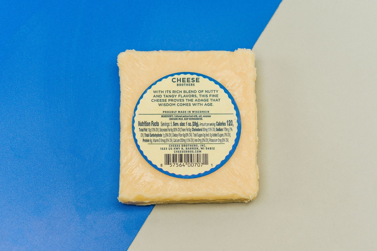 A block of 8-year-aged cheddar cheese from Cheese Brothers, Inc., showcasing a firm, golden-yellow aged cheese with a smooth texture.