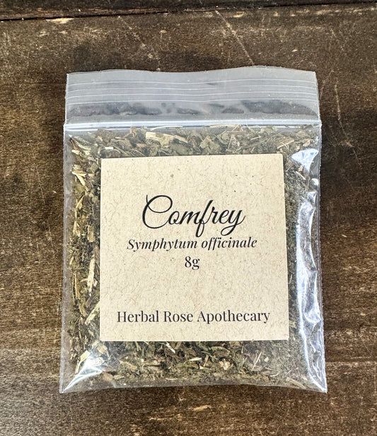 Dried comfrey herbs in an 8g package from HerbalRoseApothecary, showcasing fresh green leaves and herbal packaging.