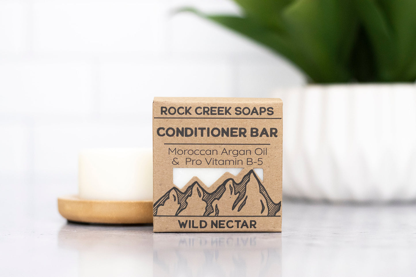 Wild Nectar conditioner bar with argan oil by Rock Creek Soaps, shown in a close-up image highlighting its natural ingredients.