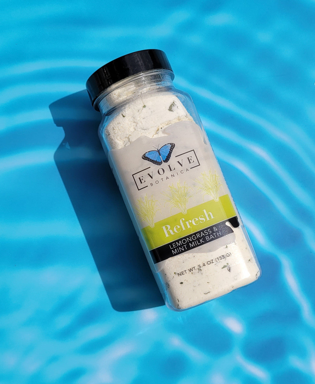 Evolve Botanica Milk Bath Refresh with lemongrass and mint, featuring a soothing white milk bath with fresh herbs and botanical elements.