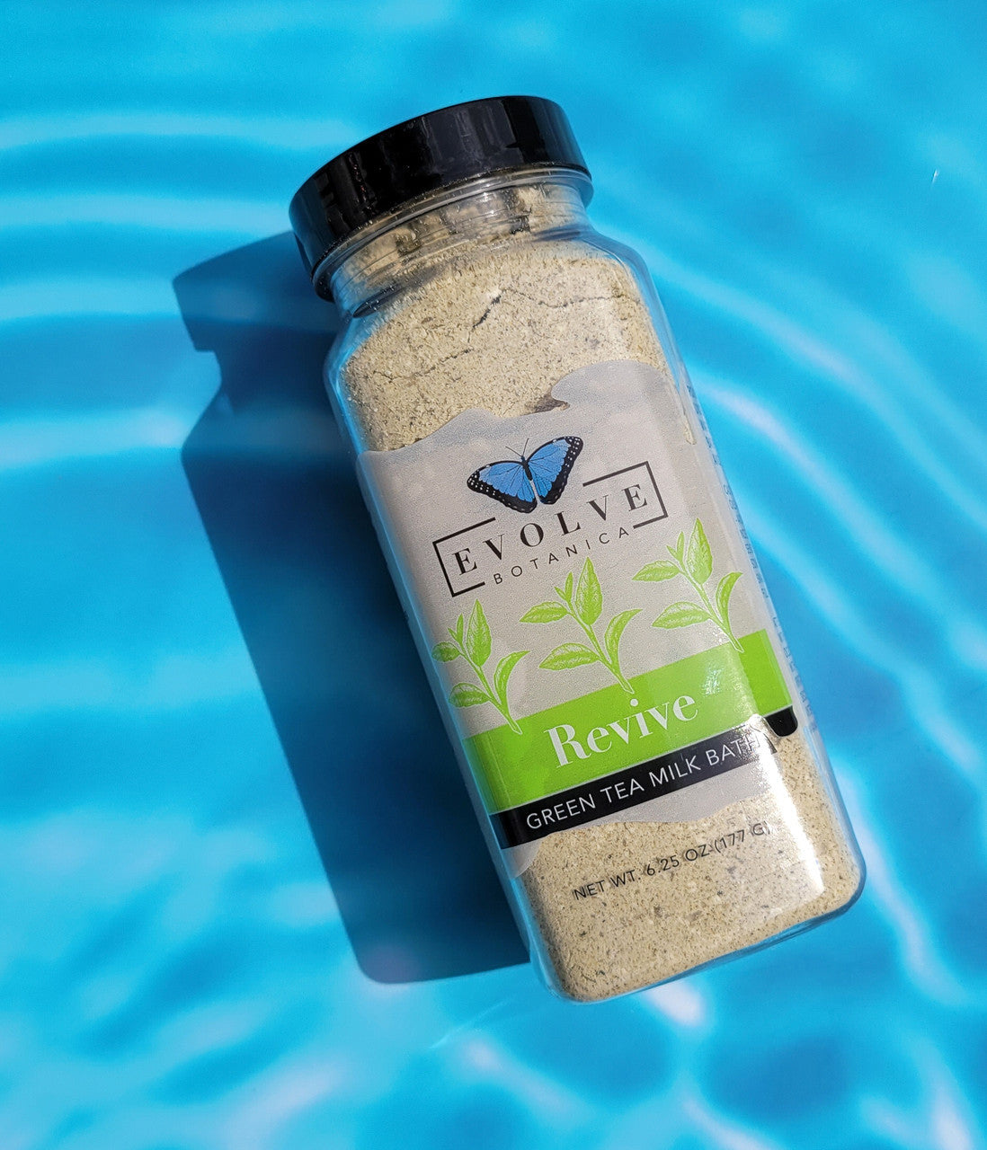 Evolve Botanica Milk Bath Revive with Green Tea in a white container, featuring green tea leaves and natural ingredients.