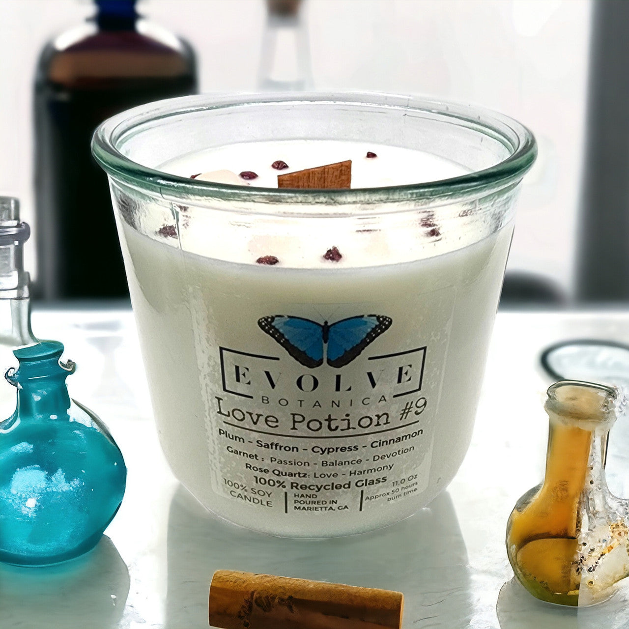 Evolve Botanica Rocks Candle Love Potion #9 with wood wick, garnet and rose quartz gemstones in a soy candle container.