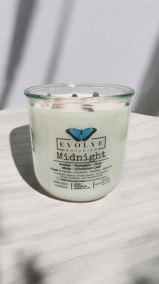 Evolve Botanica Midnight Rocks Candle with wood wick and Super Seven gemstone, soy wax, elegant dark design, calming ambiance.
