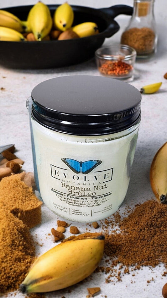 Evolve Botanica 9oz jam jar soy candle in Banana Nut Brulee scent with Citrine and Tiger's Eye crystals, natural wood wick.