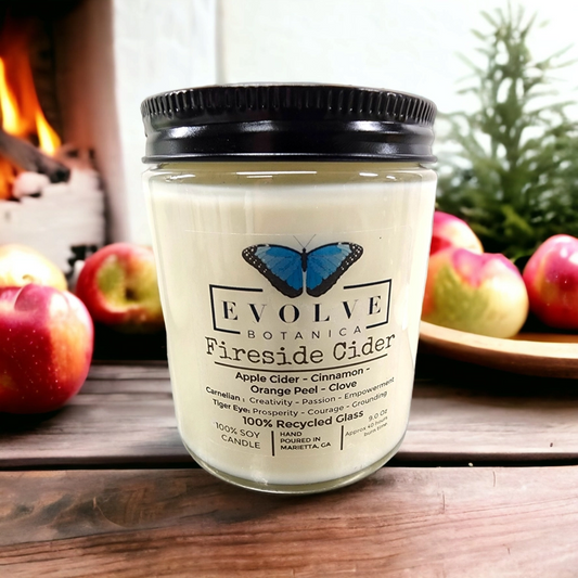 Evolve Botanica Classic 9oz jam jar soy candle with fireside cider scent, featuring Carnelian and Tigers Eye crystals and a wood wick