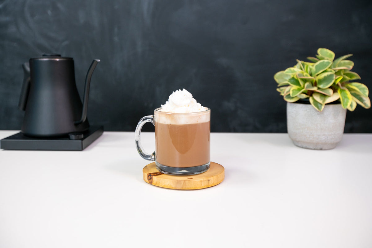 Fireside Coffee Co. French Vanilla Cafe Mocha in a coffee cup with whipped cream and vanilla flavoring on top.