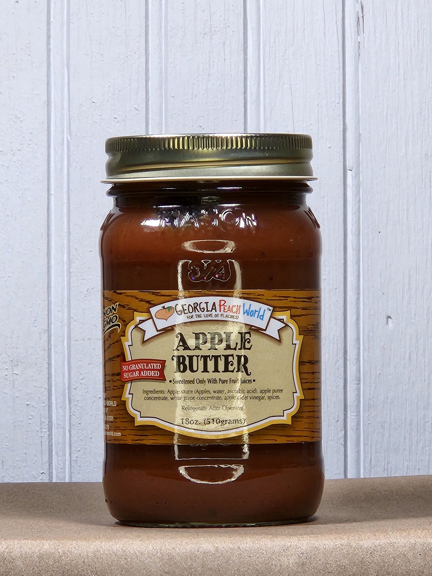 Creamy apple butter from Georgia Peach World, no sugar added, spread in a jar, showcasing a smooth, golden-brown texture.