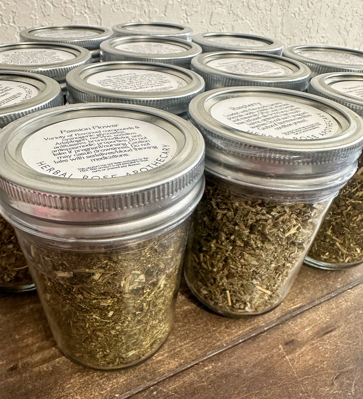 Small glass herb jars from HerbalRoseApothecary filled with dried herbs, showcasing their clear containers and colorful herb contents.