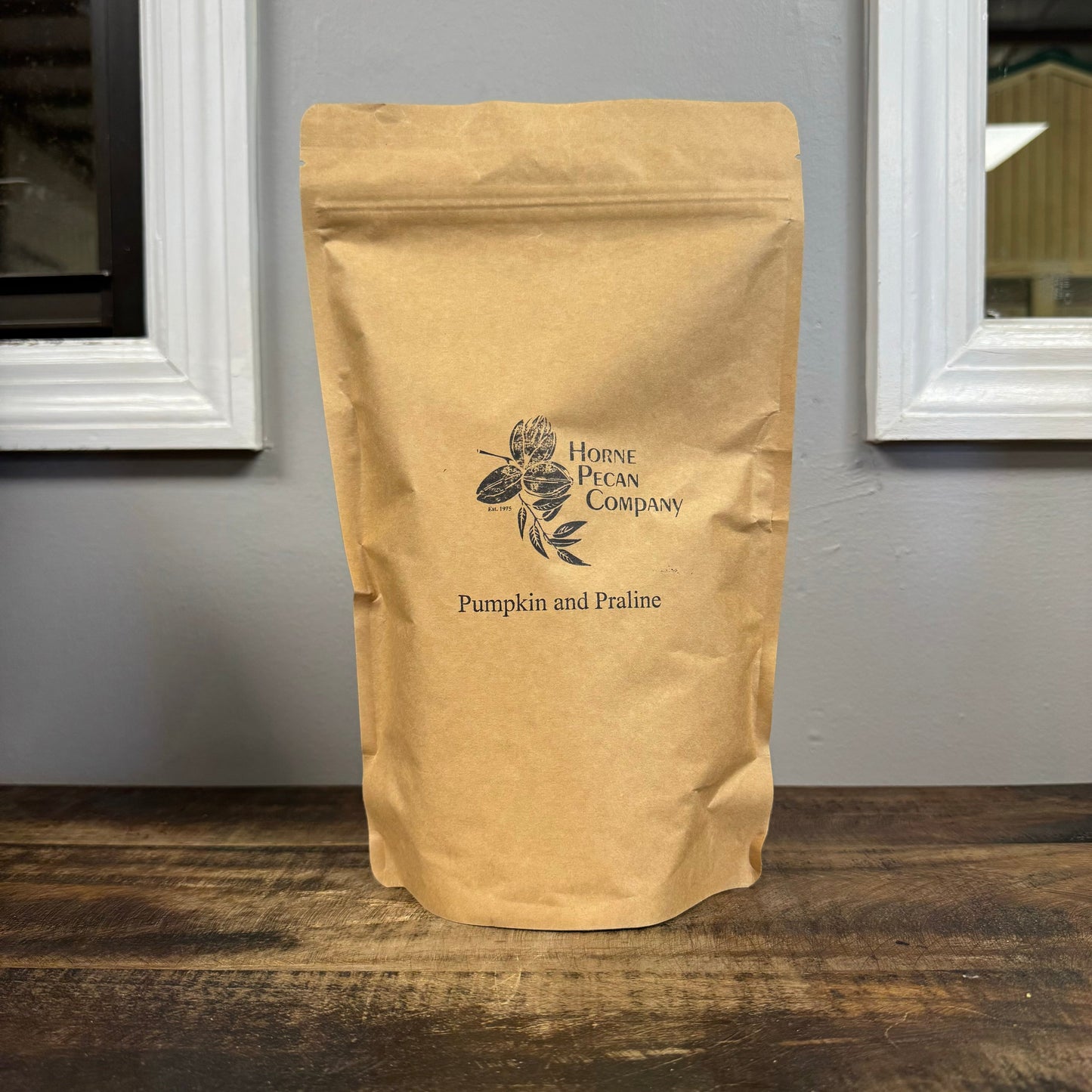 Ground gourmet pecan flavored coffee from Horne Pecan Company in a 1 lb. package, showcasing rich coffee grounds with pecan aroma.