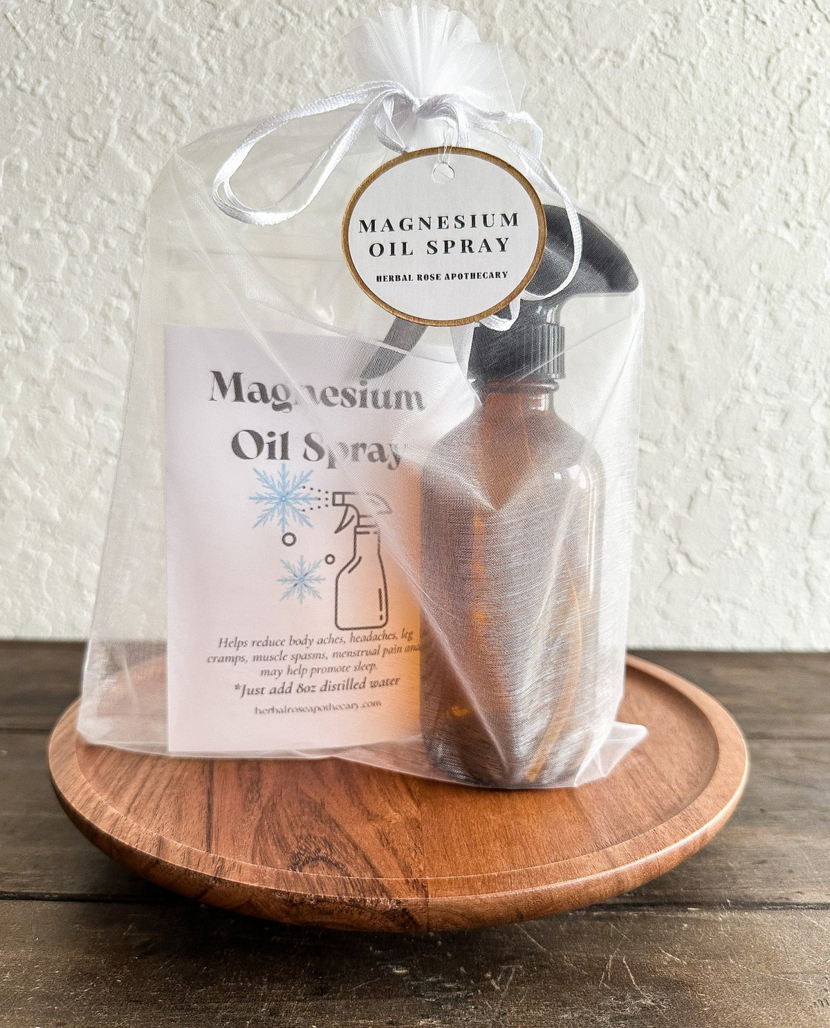 DIY magnesium oil spray in herbalroseapothecary apothecary kit with a spray bottle and natural ingredients on a wooden surface.