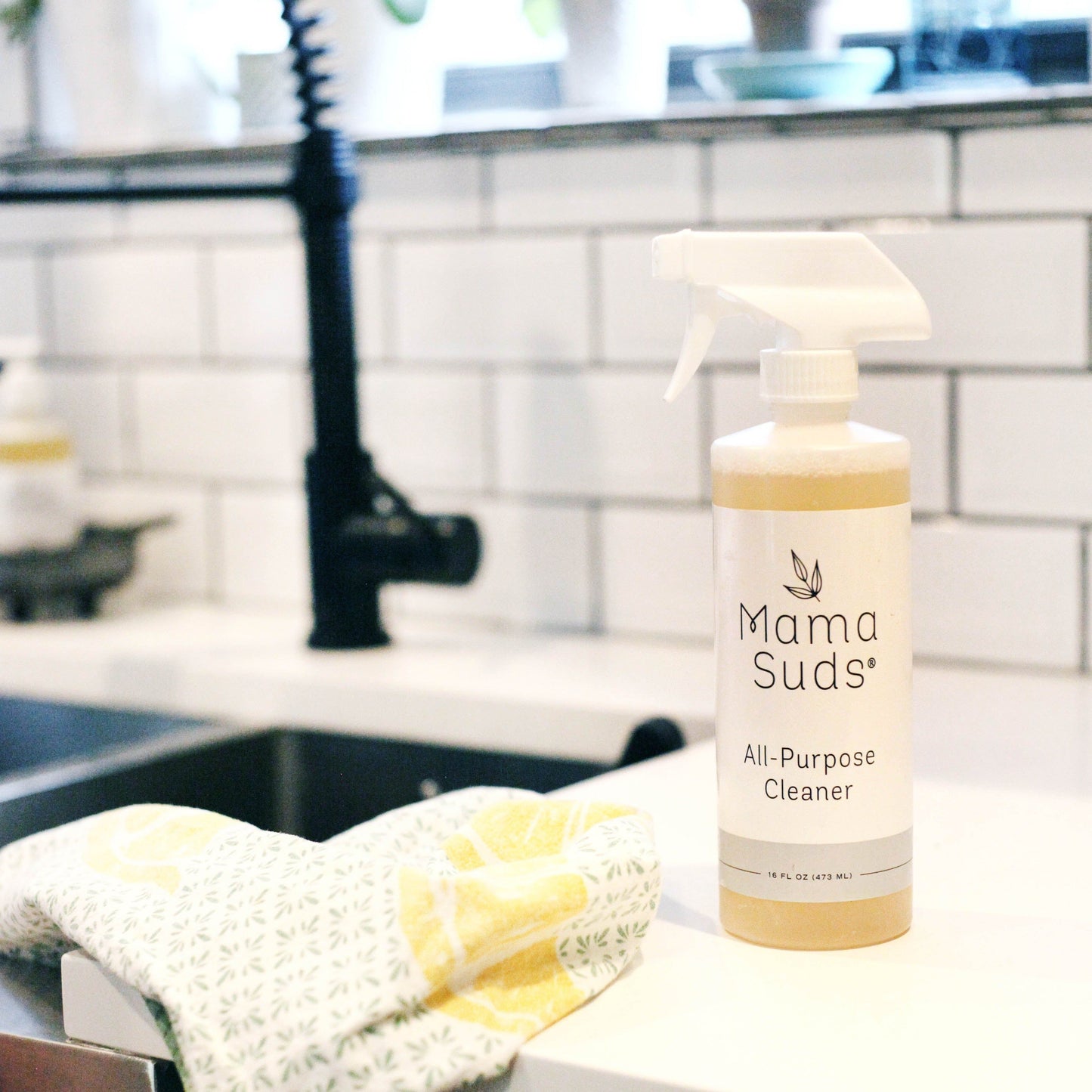 MamaSuds all-purpose cleaner spray for household cleaning, shown in a spray bottle with a green label and trigger nozzle.