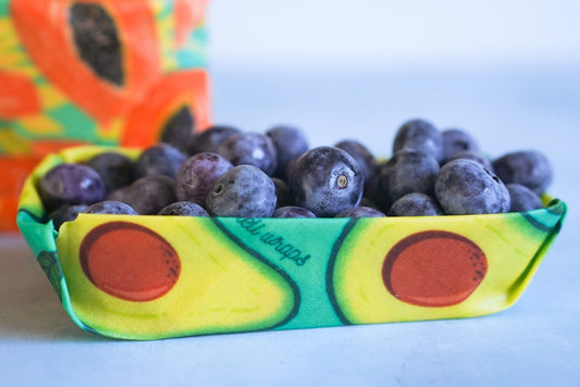 Set of four Meli Wraps beeswax wraps in fruit print, including small, medium, and large sizes for food storage and wrapping.