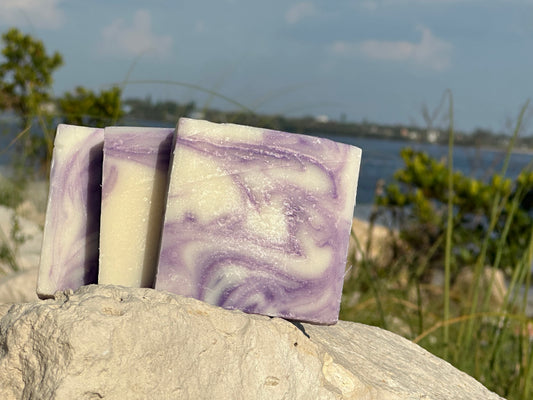 Lavender soap by Peachy Clean Soaps and More LLC with a soft purple hue and floral scent, displayed in a natural setting.