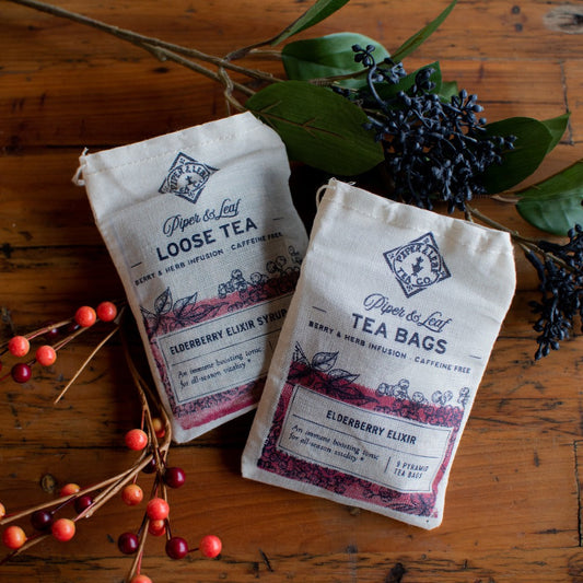 Loose leaf Elderberry Elixir tea by Piper and Leaf Tea Co., featuring dried elderberries and herbal tea leaves in a clear jar.