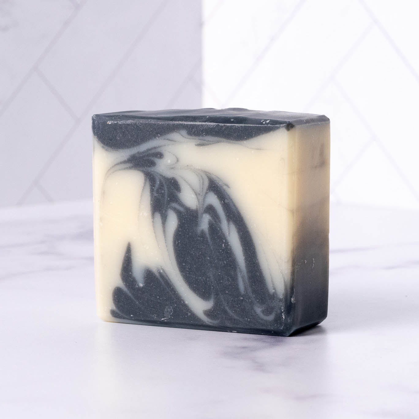 Rustic Strength detoxifying charcoal bar soap with black soap bar, highlighting its natural cleansing ingredients and textured surface.