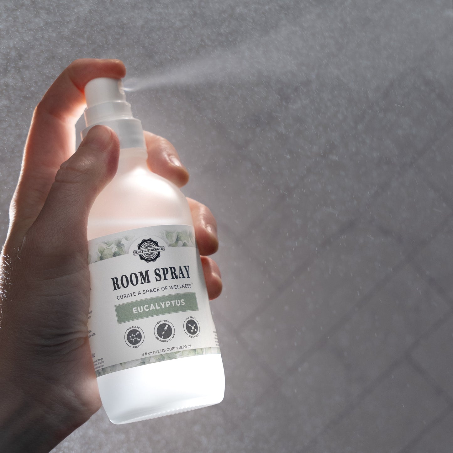 Rustic Strength aromatherapy room spray featuring a sleek glass bottle with a spray nozzle, designed for refreshing indoor spaces.