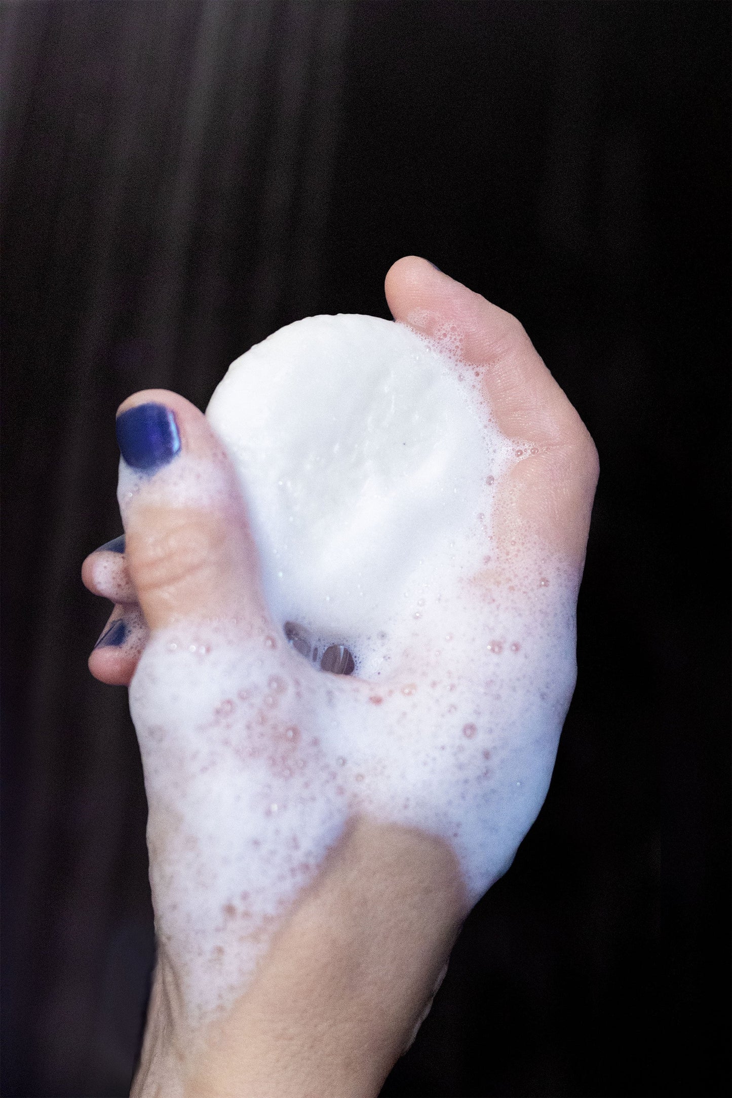Wild Nectar shampoo bar by Rock Creek Soaps with Vitamin B-5 and Argan Oil, shown in a close-up of the hand holding the bar.