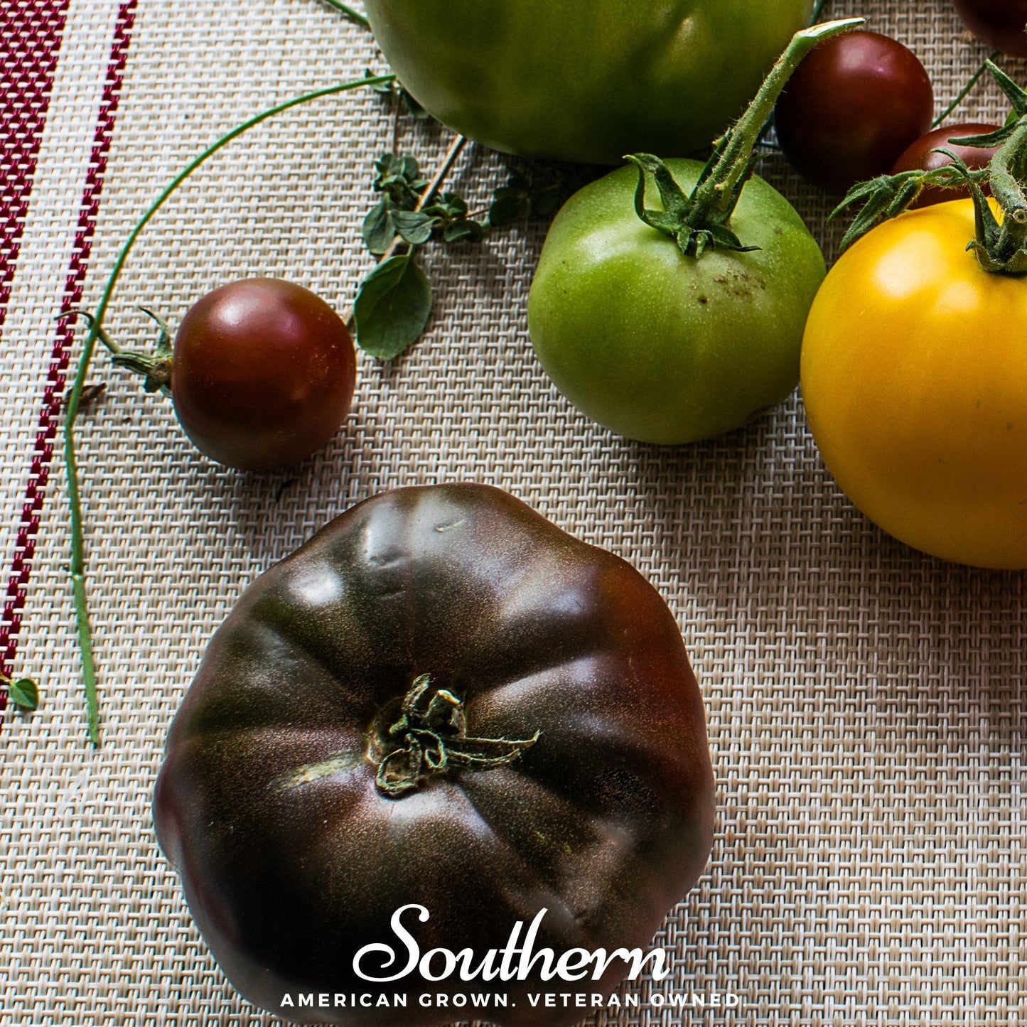 Cherokee Purple Tomato seeds from Southern Seeds, showing ripe purple heirloom tomatoes and seed packet on a garden backdrop.