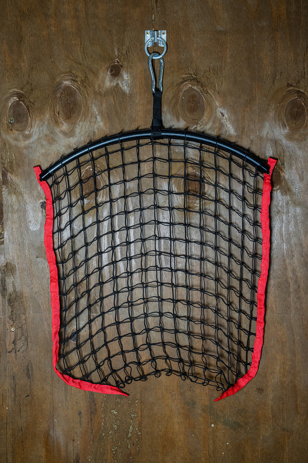 Red regular haynet from Haylo Haynets, LLC with sturdy mesh for safe hay storage and distribution.