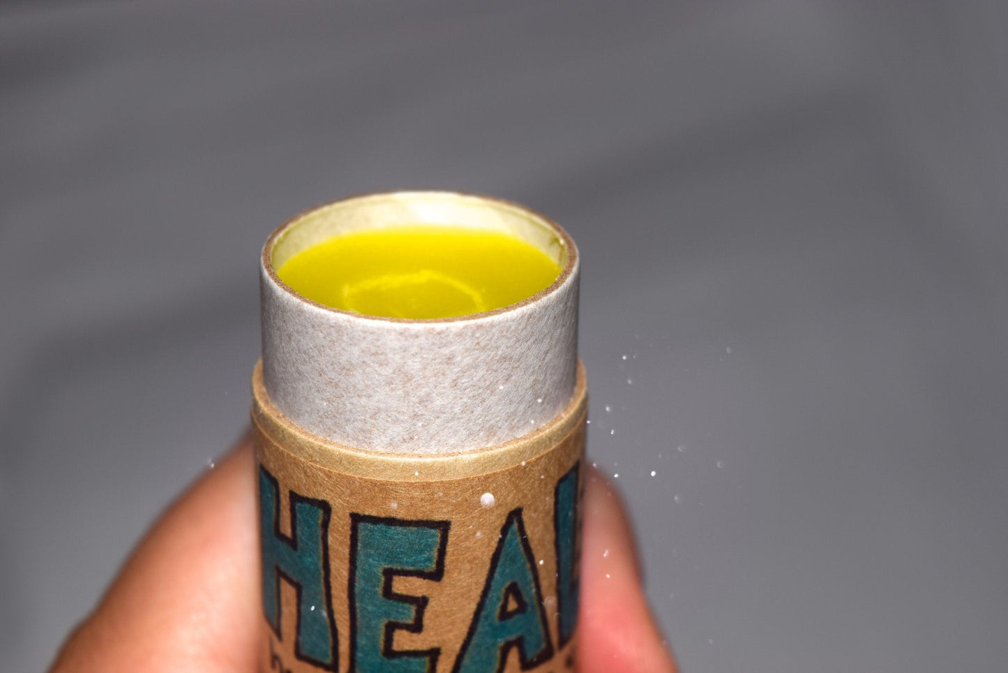 Plant Makeup Heal All Balm jar with a natural wooden lid, showcasing the skincare product in a clear glass container.