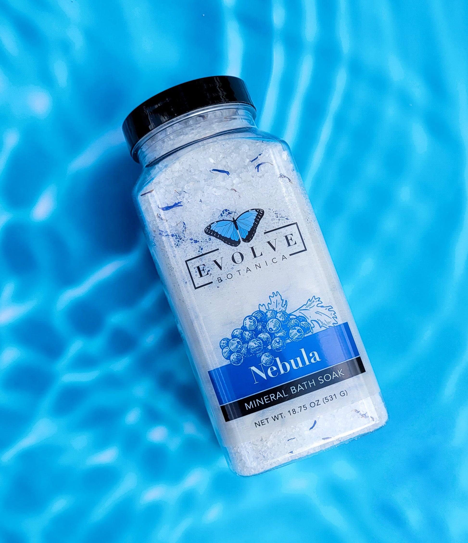 Evolve Botanica Mineral Soak Nebula bath salt in a jar, with colorful mineral crystals and a relaxing spa setting.