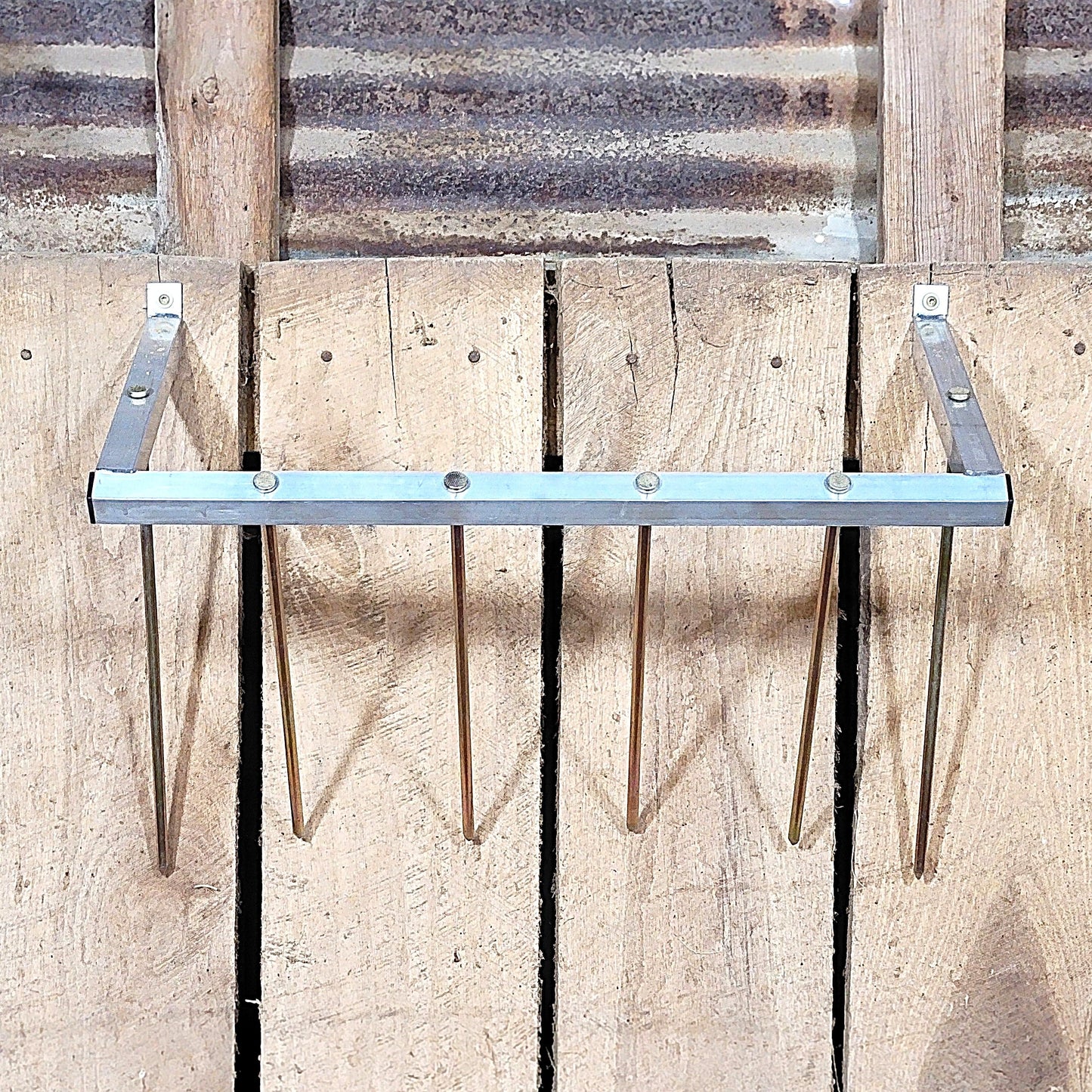 24-inch wall-mounted sheep and goat hay feeder made of aluminum, designed for fences, stalls, and pens.