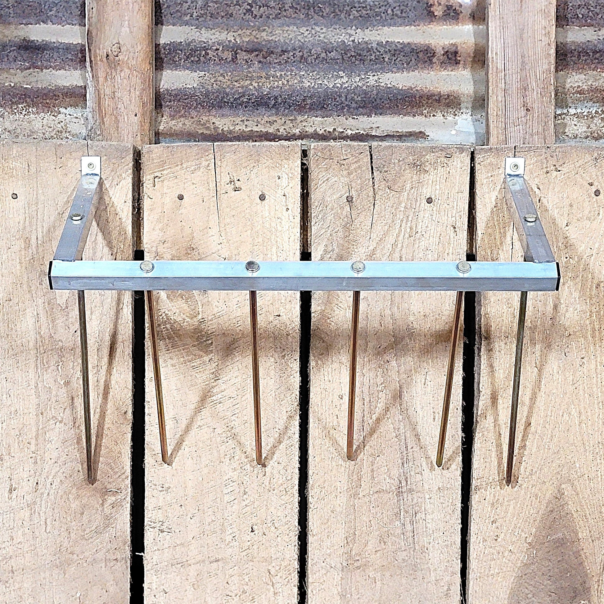 24-inch wall-mounted sheep and goat hay feeder made of aluminum, designed for fences, stalls, and pens.