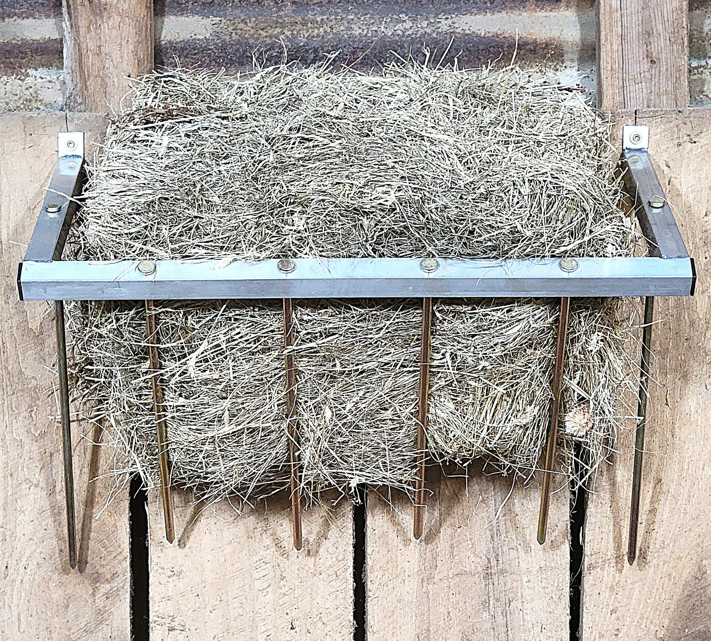 24-inch wall-mounted aluminum sheep and goat hay feeder, suitable for fences, stalls, and pens. Durable USA-made design.