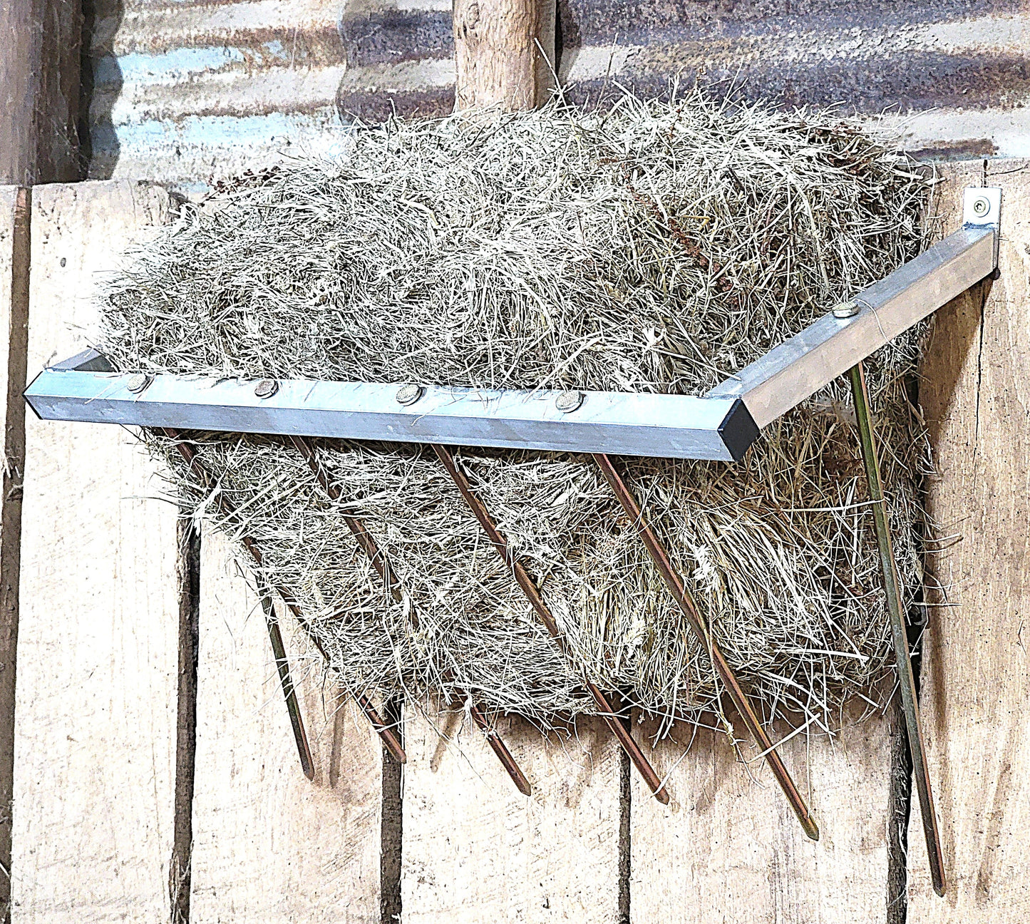 24-inch wall-mounted sheep and goat hay feeder made of USA-made aluminum, designed for fences, stalls, and pens.