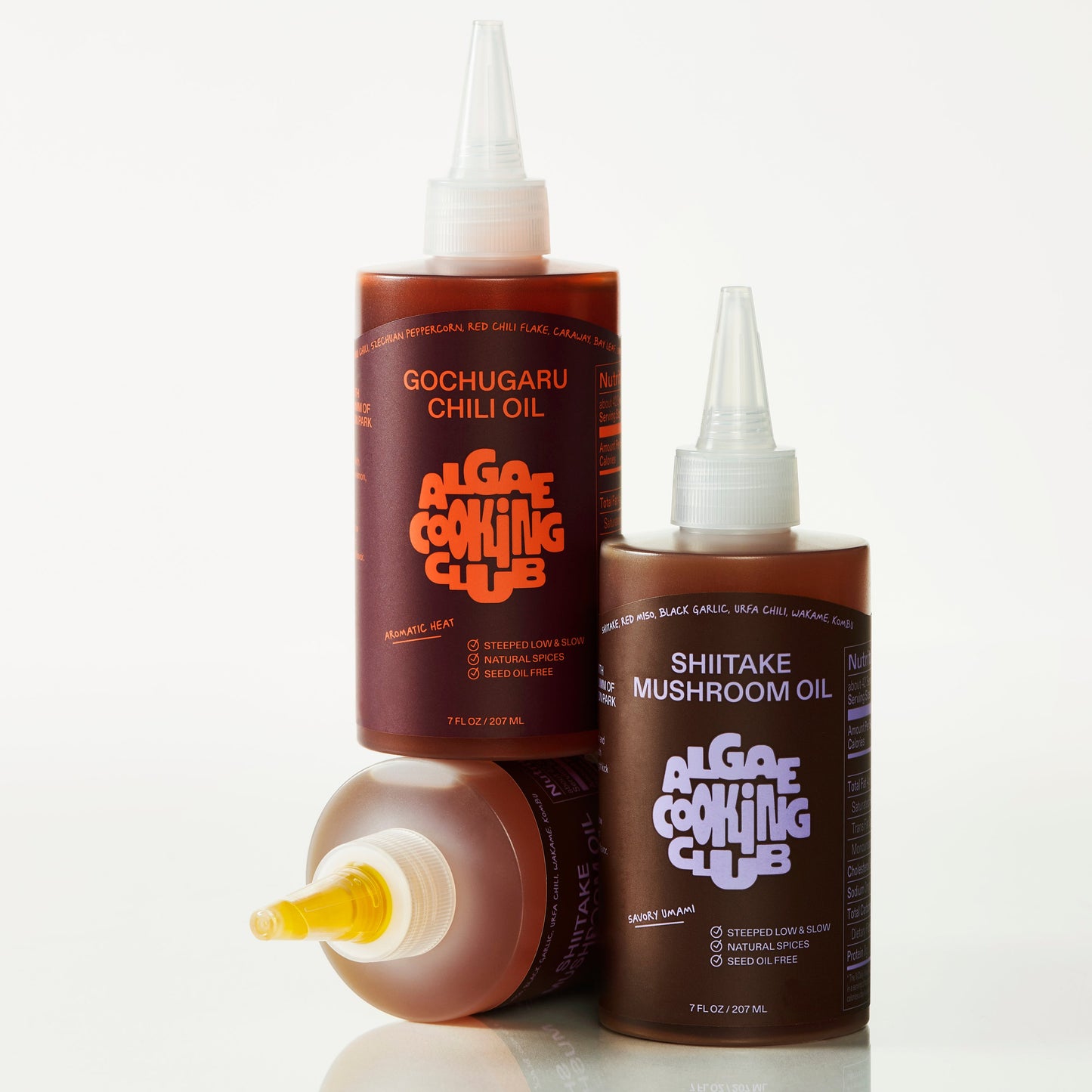 Algae Cooking Club infused oil duo bottles with green and clear labels, showcasing natural vegetable oils in glass bottles.