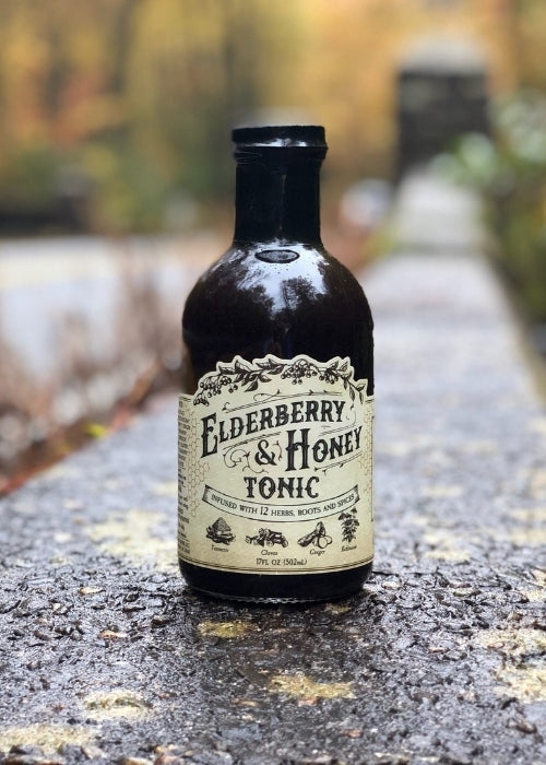 Elderberry and honey tonic bottle from Roots and Leaves LLC, with a golden liquid and natural label design.