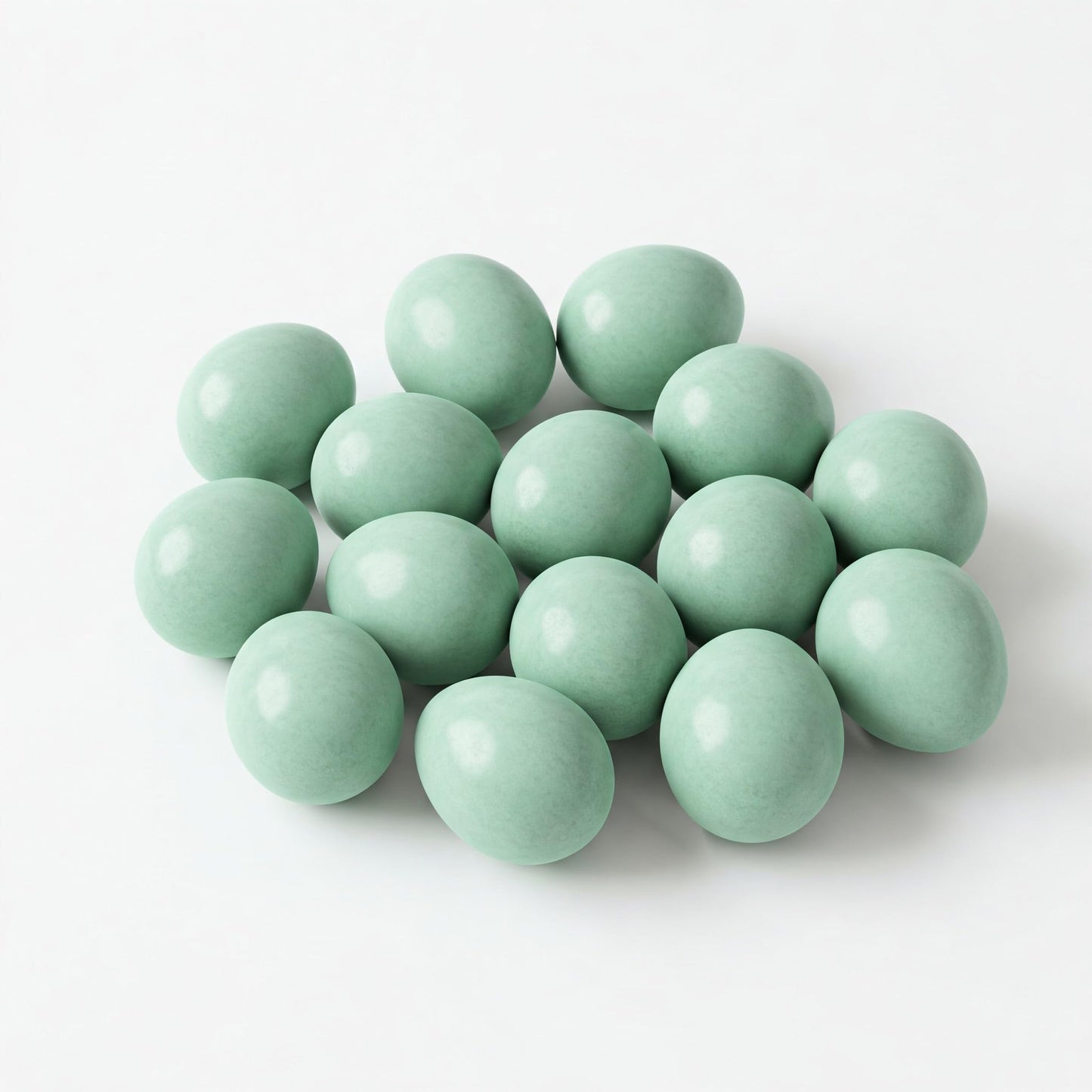 Two Celadon Coturnix hatching eggs from Quailz.com by Undique LLC, showing smooth, speckled surface and oval shape.