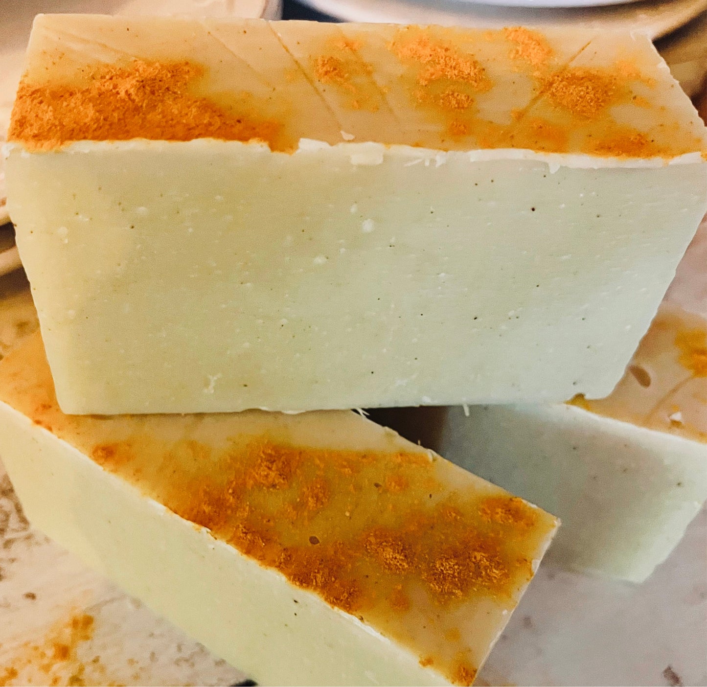 Handmade organic turmeric soap from Sweet Harvest Farms, showing a golden yellow bar with a textured surface.