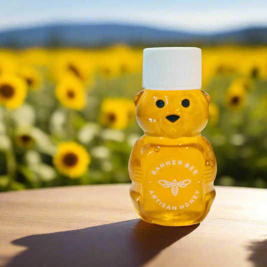 Mini honey bear jar of raw honey from BannerBee Company LLC, featuring a cute bear-shaped container filled with golden honey.