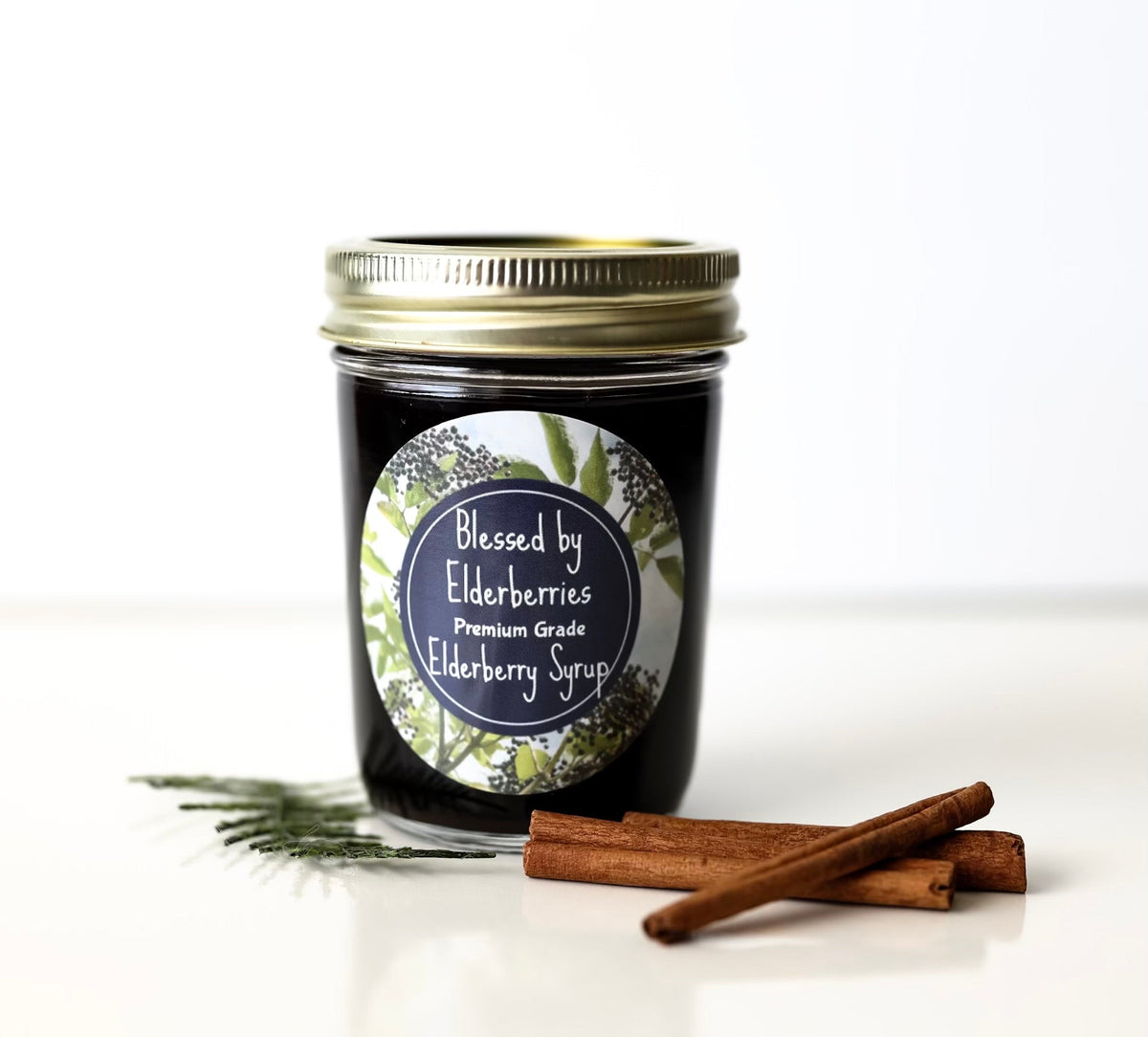 Bottle of Blessed by Elderberries elderberry syrup with a label showing fresh elderberries and natural ingredients.