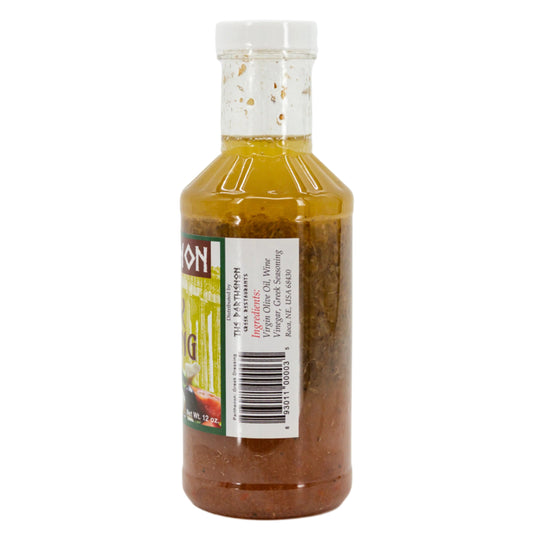 Homemade Greek dressing in a 12 oz bottle from The Parthenon Catering, featuring a creamy, herb-infused Greek salad dressing.